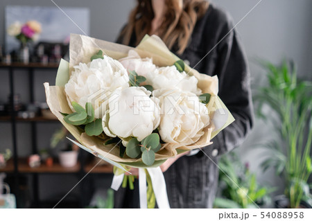 White peonies in womans hands. Beautiful fresh peony flower for catalog or online store. Floral shop 54088958