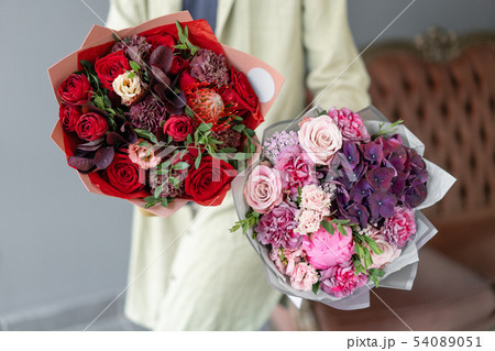 Two Small Beautiful bouquets of mixed flowers in woman hand. Floral shop concept. Flowers delivery 54089051