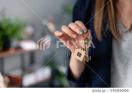 Concept of renting an apartment. House key in womans hands. Young woman. Modern light lobby interior 54089090