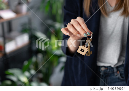 Concept of renting an apartment. House key in womans hands. Young woman. Modern light lobby interior 54089094