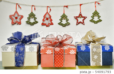 Three gift boxes with garland on shelf Three gift boxes with garland on shelf 54091793