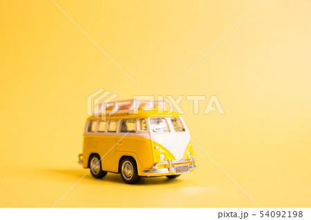 Funny yellow retro car with surfboard  54092198