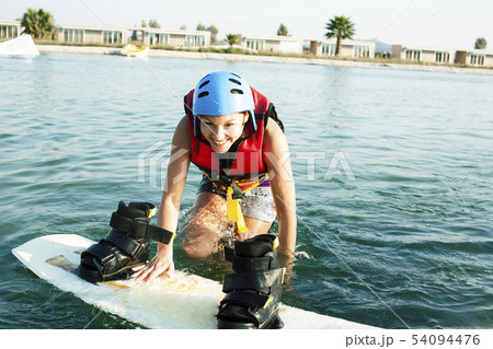 young smiling girl on wake board in water, happy lifestyle people on vacations young smiling girl on wake board in water, happy lifestyle people on vacations 54094476