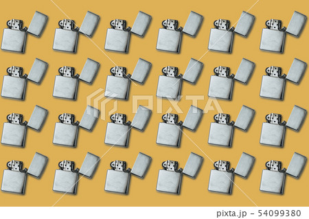 Gasoline lighter, metal lighter on a yellow Gasoline lighter, metal lighter on a yellow 54099380