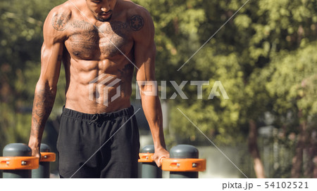 Muscular Shirtless Man Doing Push Ups On Parallel Bars 54102521