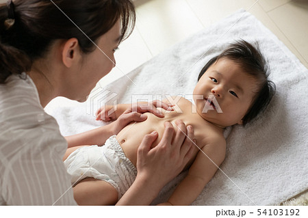赤ちゃんにベビーマッサージする母親 子育て 育児 赤ちゃんにベビーマッサージする母親 子育て 育児 54103192