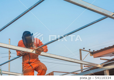 Worker welding in orange work clothes welding For Worker welding in orange work clothes welding For 54110334