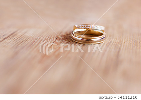 Golden wedding rings with diamonds on wooden Golden wedding rings with diamonds on wooden 54111210