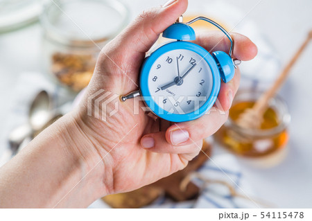 Morning alarm concept - hand with clock Morning alarm concept - hand with clock 54115478