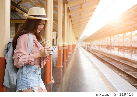 woman traveler holding camera taking photo at train station. travel trip journey 54119419