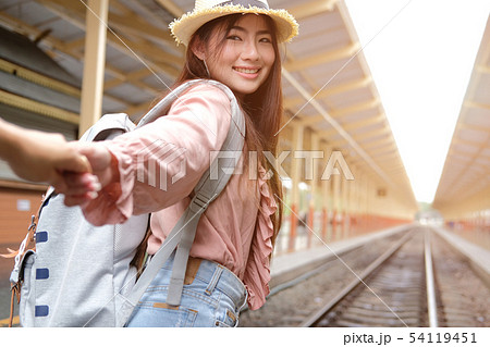 man & woman with backpack holding hands waiting for train at railway station. loving couple traveler travel together 54119451