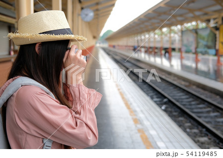woman traveler holding camera taking photo at train station. travel trip journey woman traveler holding camera taking photo at train station. travel trip journey 54119485
