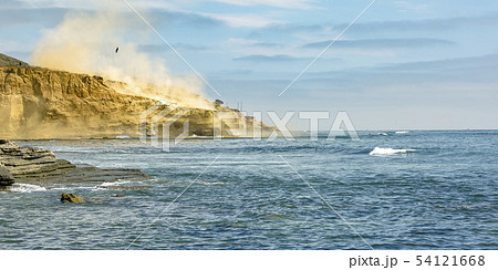 Person hanging on a chopper over cliff and ocean 54121668
