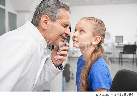 Oculist looking through special tool at eye pupil in clinic 54129094