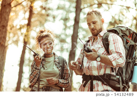 Joyful active couple speaking on walkie talkies 54132489
