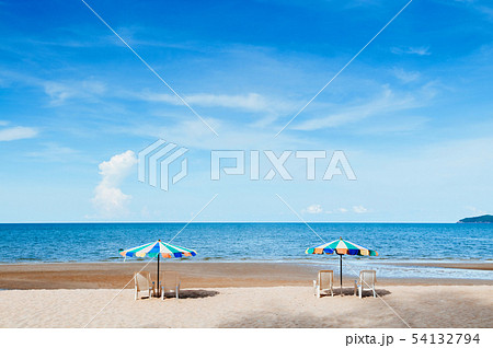 Beach beds and colourful umbrellas with ocean 54132794