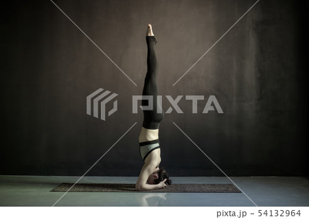 Young woman working out yoga doing salamba sirsasana Young woman working out yoga doing salamba sirsasana 54132964