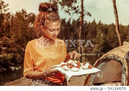 Nice young woman holding a plate with food 54134070