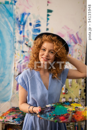 Young appealing artist holding palette with colorful paints 54135948