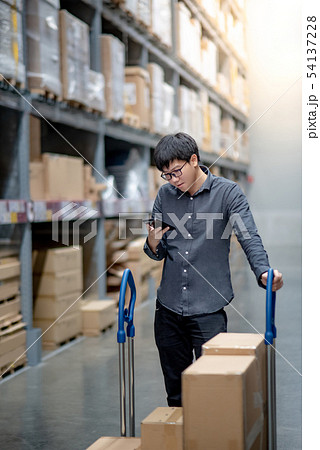 Asian shopper checking shopping list in warehouse Asian shopper checking shopping list in warehouse 54137228