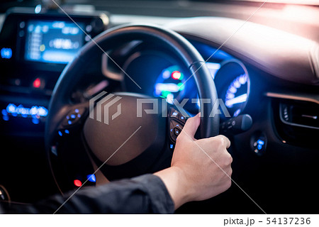 Driver hand holding steering wheel in the car 54137236