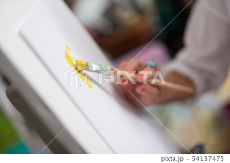 Close up of painting brush with bright yellow gouache 54137475