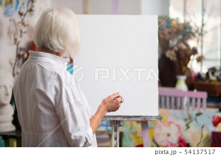 Woman standing near white canvas before painting Woman standing near white canvas before painting 54137517