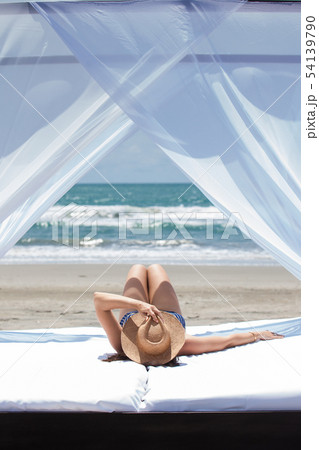 Woman relaxing at a paradisiac tropical beach Woman relaxing at a paradisiac tropical beach 54139790