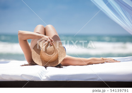 Woman relaxing at a paradisiac tropical beach Woman relaxing at a paradisiac tropical beach 54139791