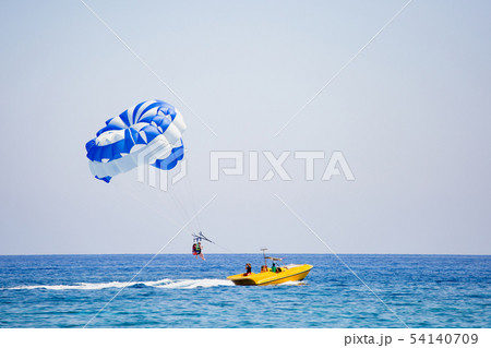 Photographer making a photo of couple of tourists flying on a parachute 54140709