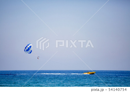 Couple of tourists flies on a blue and white parachute 54140754