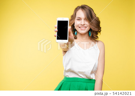 Girl showing mobile to the camera with shocked Girl showing mobile to the camera with shocked 54142021