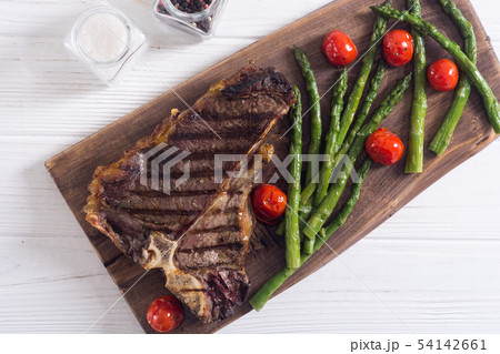 Grilled T-bone steak with asparagus and cherry 54142661