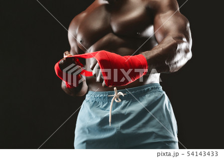 Strong african man wrapping hands with boxing wraps 54143433