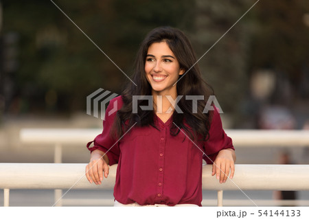 Pretty woman leaning on railing outdoors, walking in city Pretty woman leaning on railing outdoors, walking in city 54144133