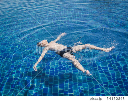 Happy Asian preteen boy floating on swimming pool 54150843