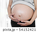 Body part pregnant belly near window at home. 54152421
