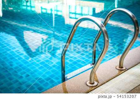 metal steel handle at edge poolside of swimming pool in hotel 54153207