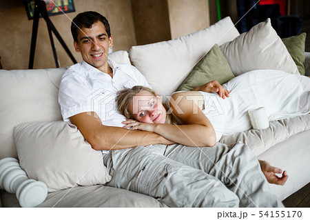 Happy pregnant beautiful blonde is lying on the lap of her beloved husband 54155170