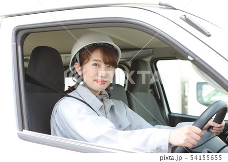 運転席に座る作業着を着た若い女性 54155655
