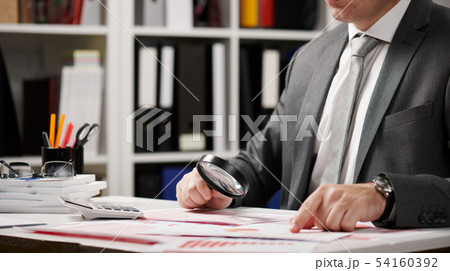Businessman working and calculating, reads and Businessman working and calculating, reads and 54160392
