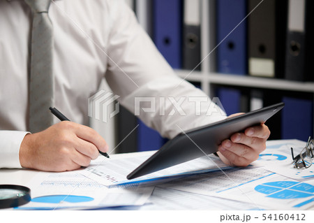 Businessman working with tablet pc, calculating, 54160412