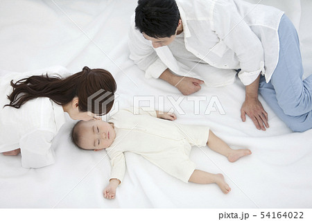 赤ちゃんを見守る両親 54164022