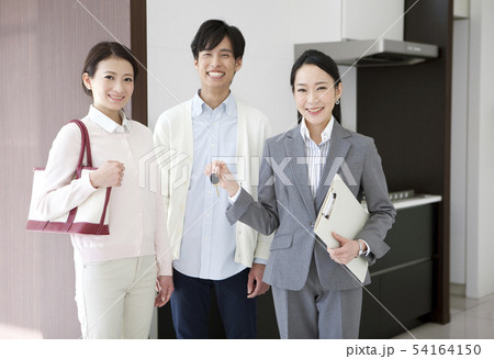 鍵を持つビジネスウーマンと笑顔の夫婦 54164150