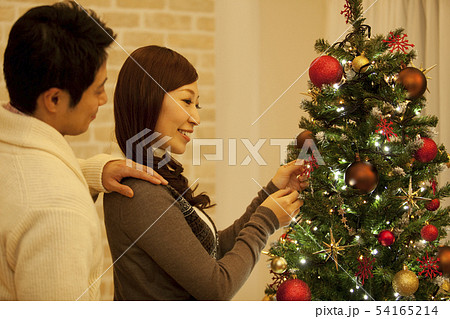 クリスマスツリーを飾るカップル クリスマスツリーを飾るカップル 54165214