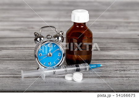 Alarm clock with syringe, pills and medical bottle 54166675