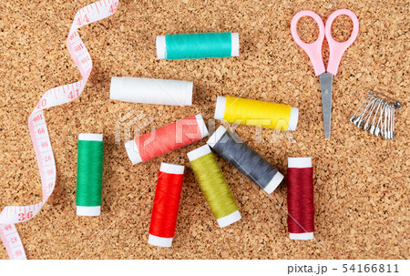 Sewing kit with colorful spools of threads and 54166811