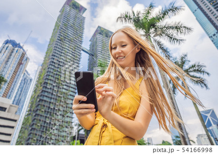 Woman Tourist using navigation app on the mobile phone. Navigation map on a smartphone in a big city 54166998
