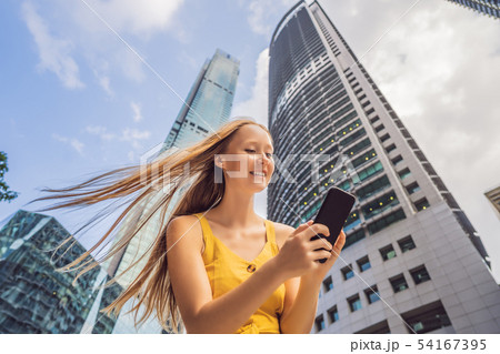 Woman Tourist using navigation app on the mobile phone. Navigation map on a smartphone in a big city Woman Tourist using navigation app on the mobile phone. Navigation map on a smartphone in a big city 54167395