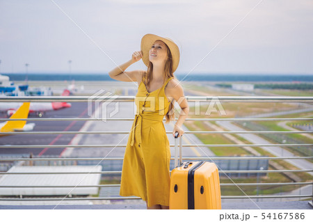 Start of her journey. Beautiful young woman ltraveler in a yellow dress and a yellow suitcase is Start of her journey. Beautiful young woman ltraveler in a yellow dress and a yellow suitcase is 54167586